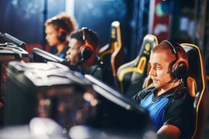 Male cybersport gamer wearing headphones playing online video games